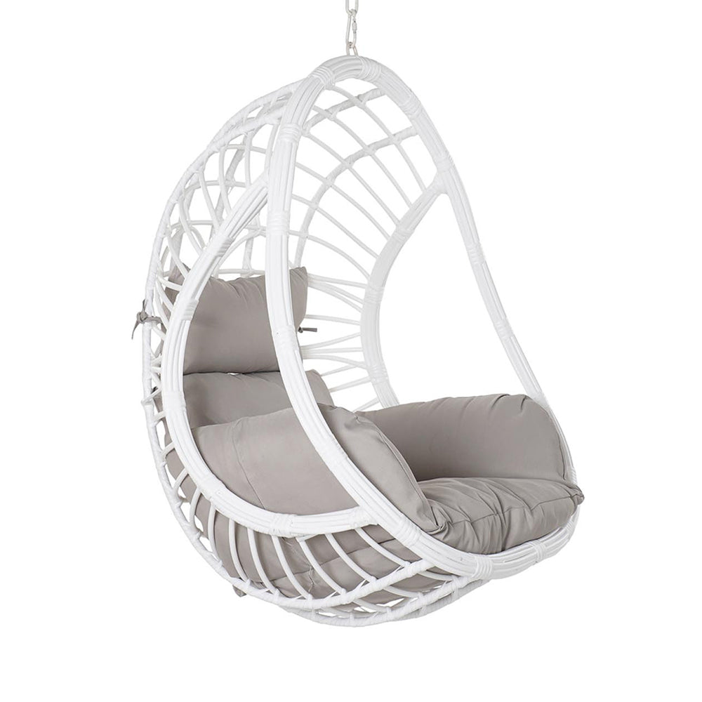 Aurora Nest fehér színű műrattan kerti függőfotel bézs párnákkal, fehér háttér előtt, oldalnézetből.
