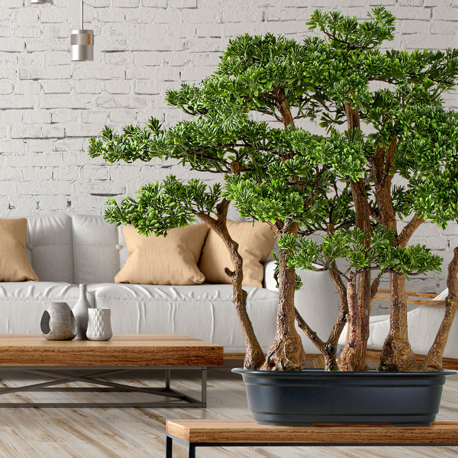 Zöld színű, mű tea bonsai fa, fekete színű műanyag cserépben.