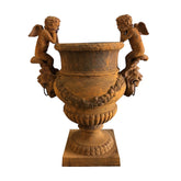 Antikolt öntöttvas díszkaspó könyöklő puttófigurákkal és klasszikus ornamentikával, Château Jardin kollekció, 100 cm magas.