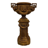 Antikolt öntöttvas díszkaspó posztamenssel, klasszikus kastélykerti stílusban, rozsdaszínű felülettel, 142 cm magas.