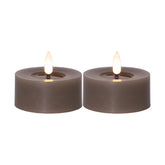 Két darab szürkésbarna színű, valódi viaszból készült LED teamécses meleg fényű, égő lángot utánzó hatással, fehér háttéren.