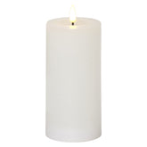 Fehér, henger alakú LED gyertya meleg fényű lánggal, a Star Trading FLOW kollekció 7,5 x 17,5 cm-es, élethű viaszbevonatú változata.