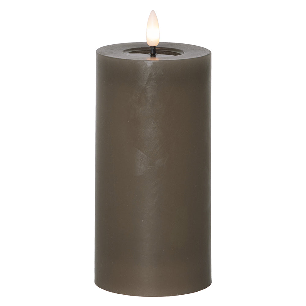 Szürkésbarna, henger alakú LED gyertya meleg fehér lánggal, fehér háttér előtt, 17,5 cm magas kivitelben.