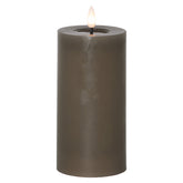 Szürkésbarna, henger alakú LED gyertya meleg fehér lánggal, fehér háttér előtt, 17,5 cm magas kivitelben.