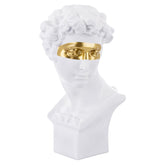 Aranyszínű maszkkal kontrasztozott, nagy méretű, fehér színű férfi mellszobor..