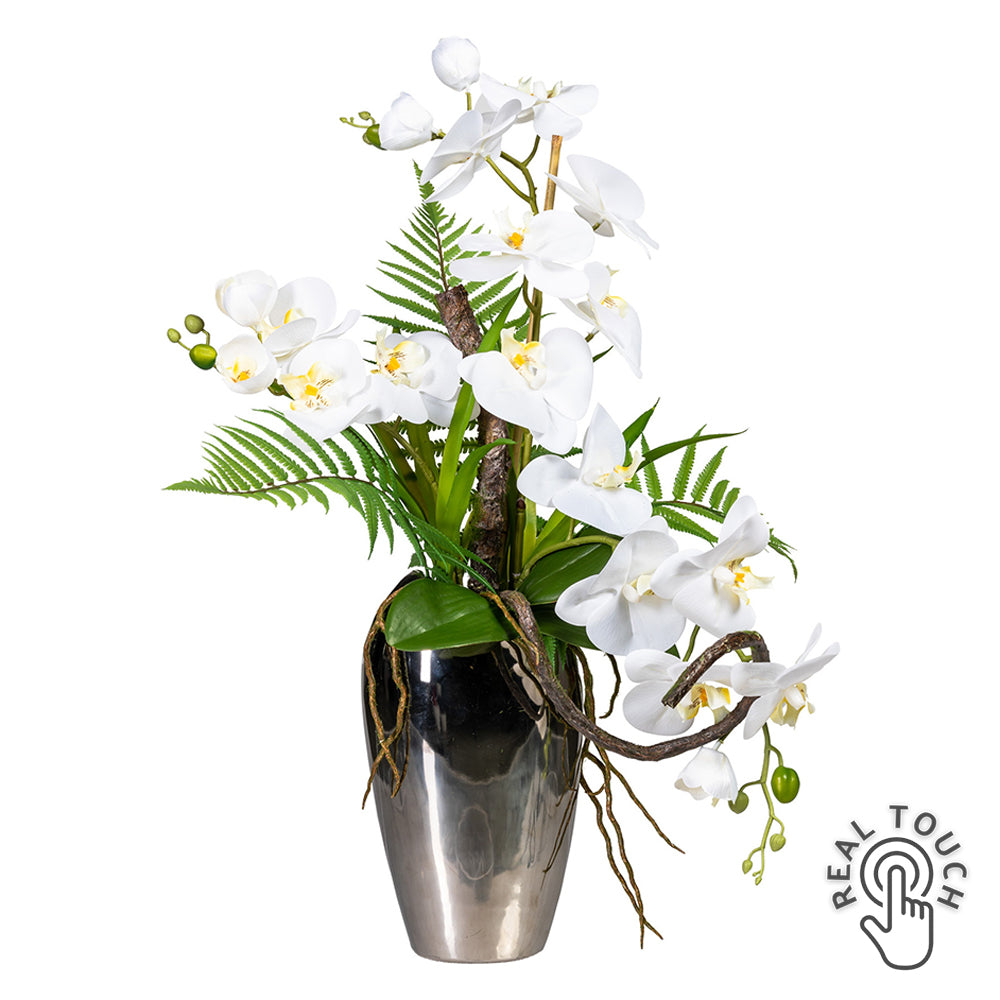 Fehér mű orchidea kompozíció ezüst kerámia vázában, páfránylevelekkel.