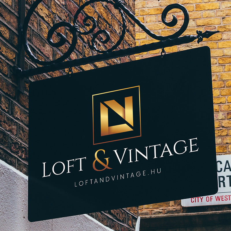 Loft and Vintage storefront sign with gold logo hanging on a decorative iron bracket against a brick wall
