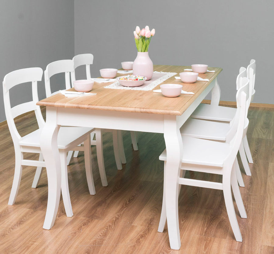 MAISON fenyő étkezőasztal 180 cm hosszú ívelt lábakkal, természetes fa felülettel fehér székekkel körülvéve középen rózsaszín vázában tulipánnal