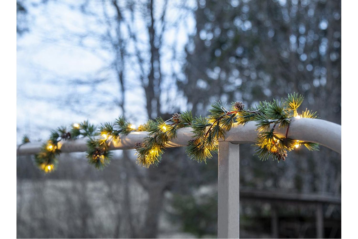 LED-es vörösfenyő girlanddal díszített kültéri korlát. LED-es vörösfenyő girlanddal díszített kültéri korlát.