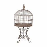 Fémből készült, ovális formájú, barna színű, 70 cm hosszú és 142 cm magas, díszes lábakon álló, vintage stílusú madárkalitka.