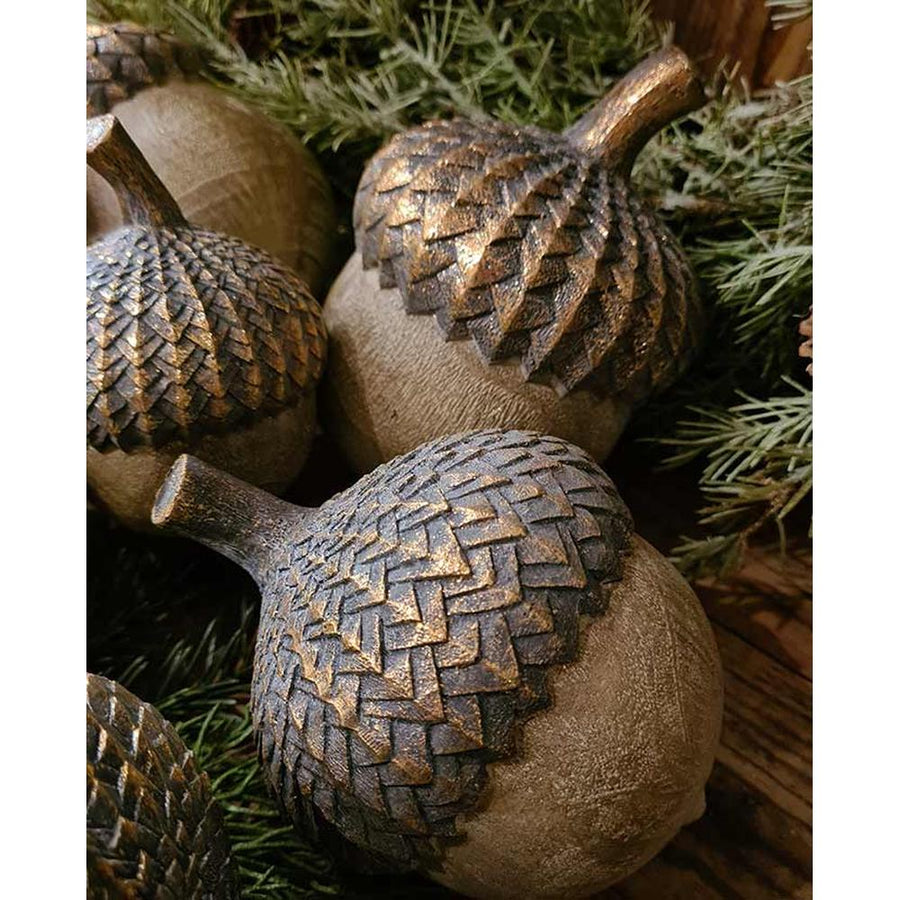 Vintage, rusztikus stílusú, 16 cm hosszú fa hatású, antik arany színnel patinázott karácsonyi makk díszek fenyőágak között