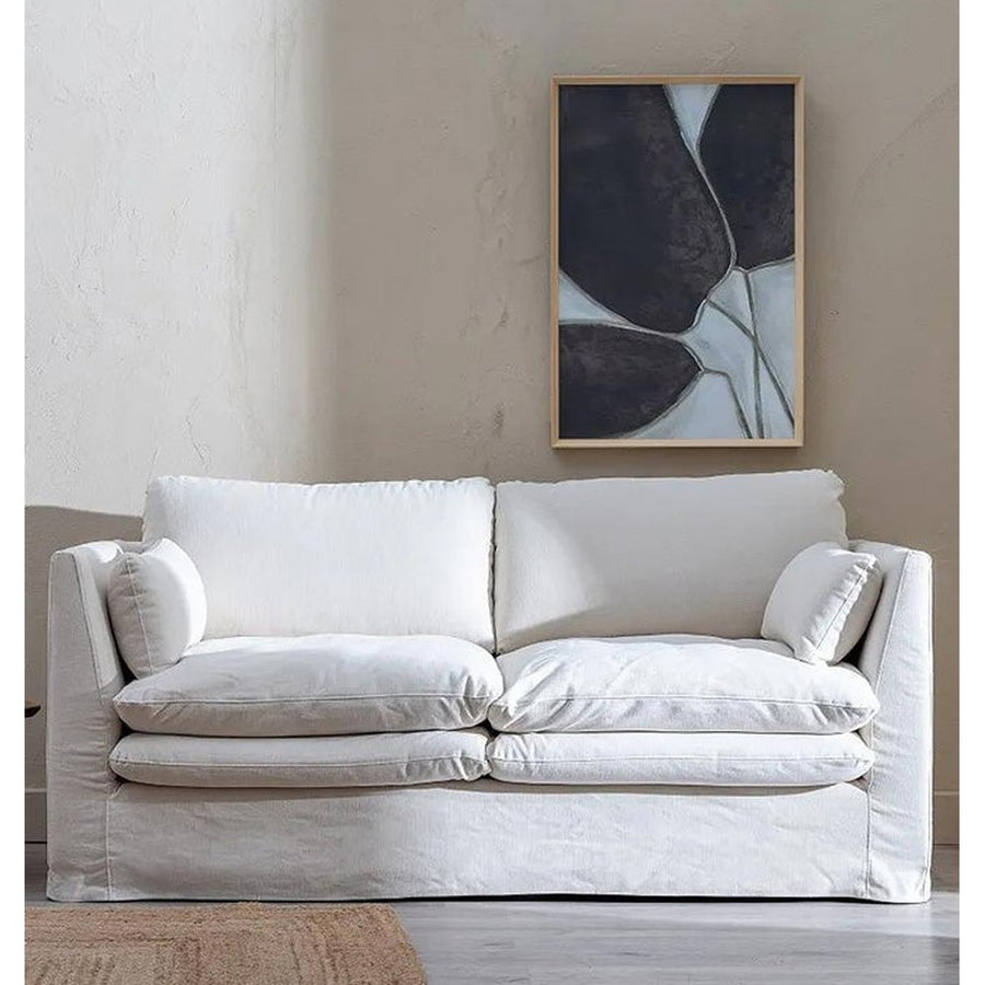 Bézs színű pamutvászon kárpitozású, kényelmes párnákkal ellátott kortárs kanapé..