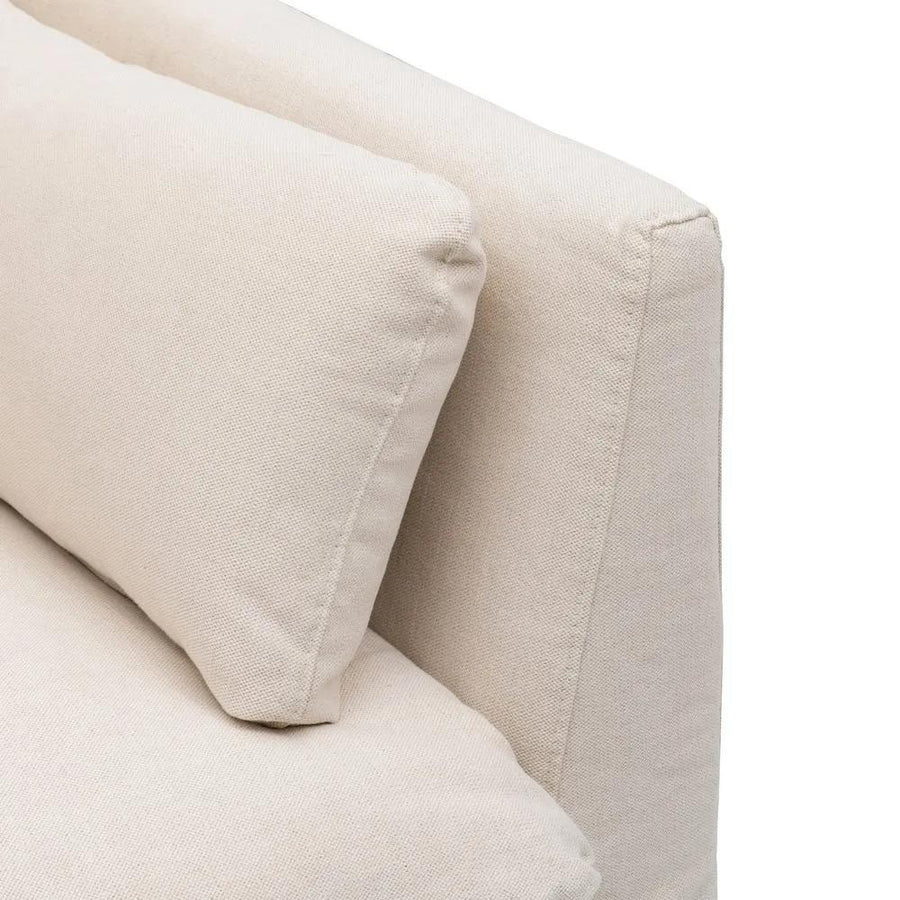 Bézs színű pamutvászon kárpitozású, kényelmes párnákkal ellátott kortárs kanapé..