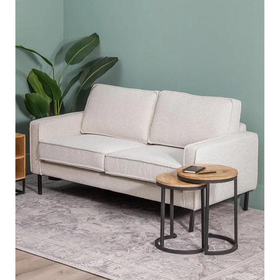 Fehér színű szövettel kárpitozott, 2 személyes kanapé.