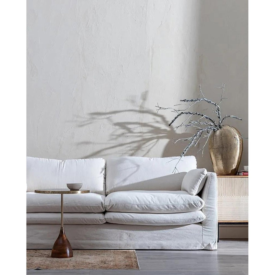 Bézs színű pamutvászon kárpitozású, kényelmes párnákkal ellátott kortárs kanapé.