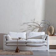 Bézs színű pamutvászon kárpitozású, kényelmes párnákkal ellátott kortárs kanapé.