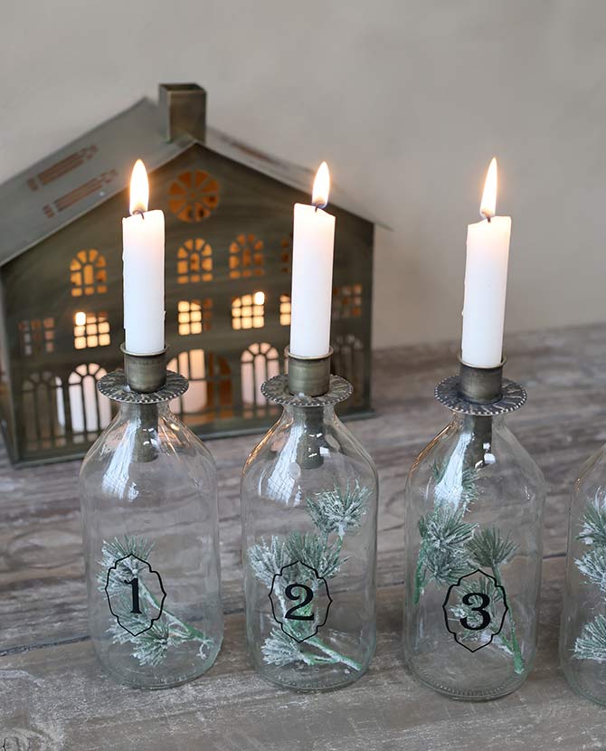 4 darabos, számozott díszítésű üvegpalackba kialakított adventi gyertyatartó szett.