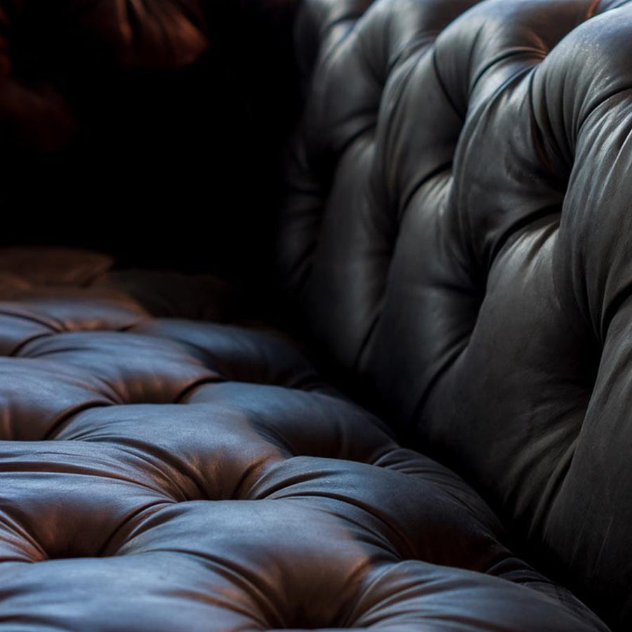 Szegecselt alumínium lemez borítású, montaigne fekete színű kecskebőrrel kárpitozott design kanapé.