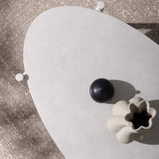 Bézs színű kerti dohányzóasztal, fehér színű kő asztallappal napsütötte terszon felülnézetből