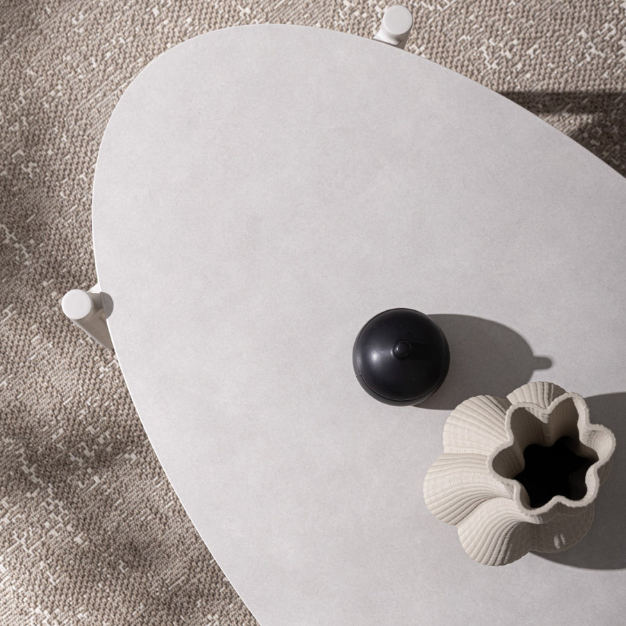 Bézs színű kerti dohányzóasztal, fehér színű kő asztallappal napsütötte terszon felülnézetből