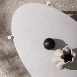 Bézs színű kerti dohányzóasztal, fehér színű kő asztallappal napsütötte terszon felülnézetből