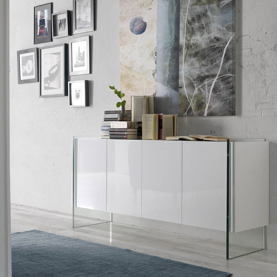Kortárs stílusú, magasfényű, fehér színű lakkal festett, dizájn komódszekrény edzett üveg lábakkal.