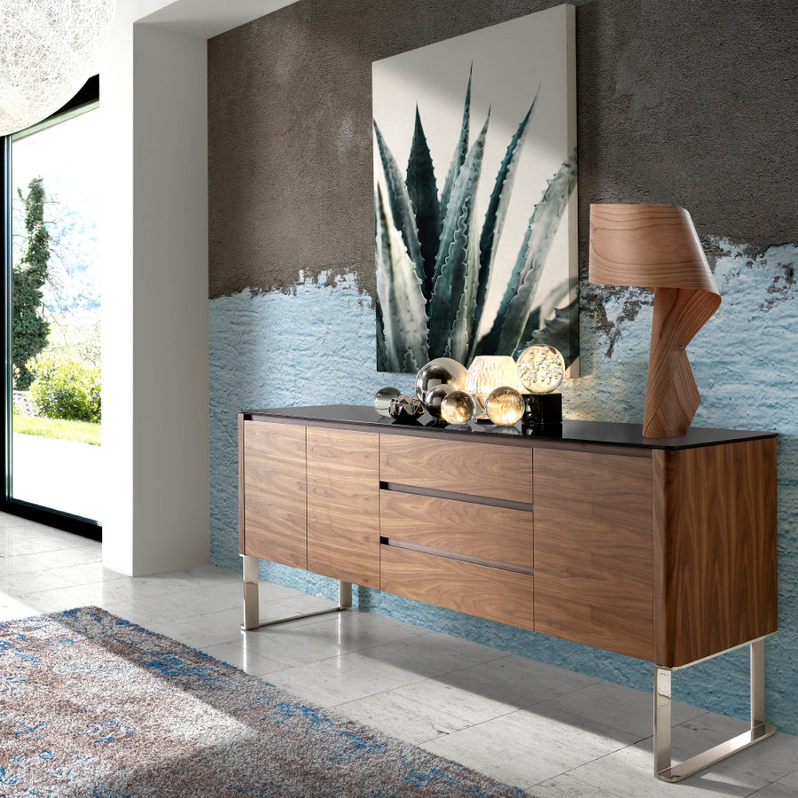 Kortárs stílusú, diófa furnérral borított, dizájn komódszekrény fekete edzett üveg fedlappal.