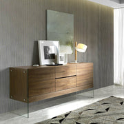 Kortárs stílusú, diófa furnérral borított, dizájn komódszekrény edzett üveg lábakkal.