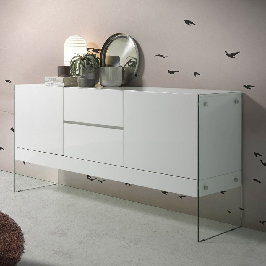 Kortárs stílusú, magasfényű, fehér színű lakkal festett, dizájn komódszekrény edzett üveg lábakkal.