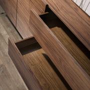 Kortárs stílusú, diófa furnérral borított design, MDF komódszekrény edzett üveg lábakkal.