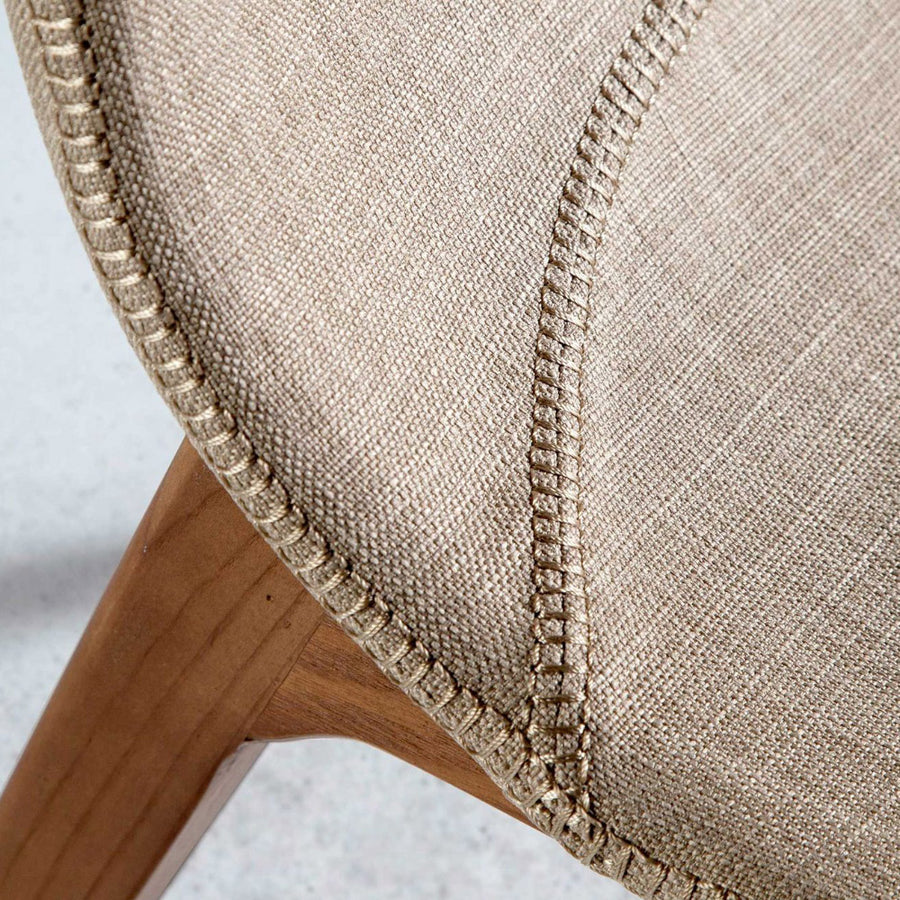 Bézs színű szövettel kárpitozott, kőrisfából készült étkezőszék.