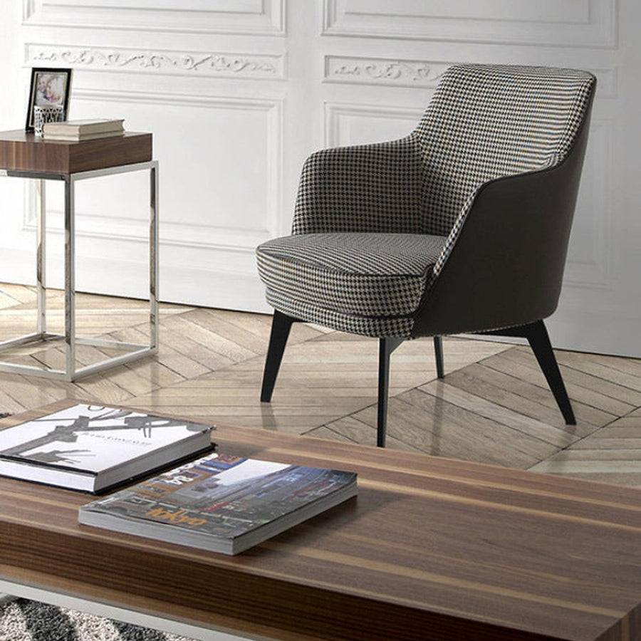 Kortárs stílusú, fekete színű műbőrrel és pepita színű szövettel kárpitozott dizájn fotel.