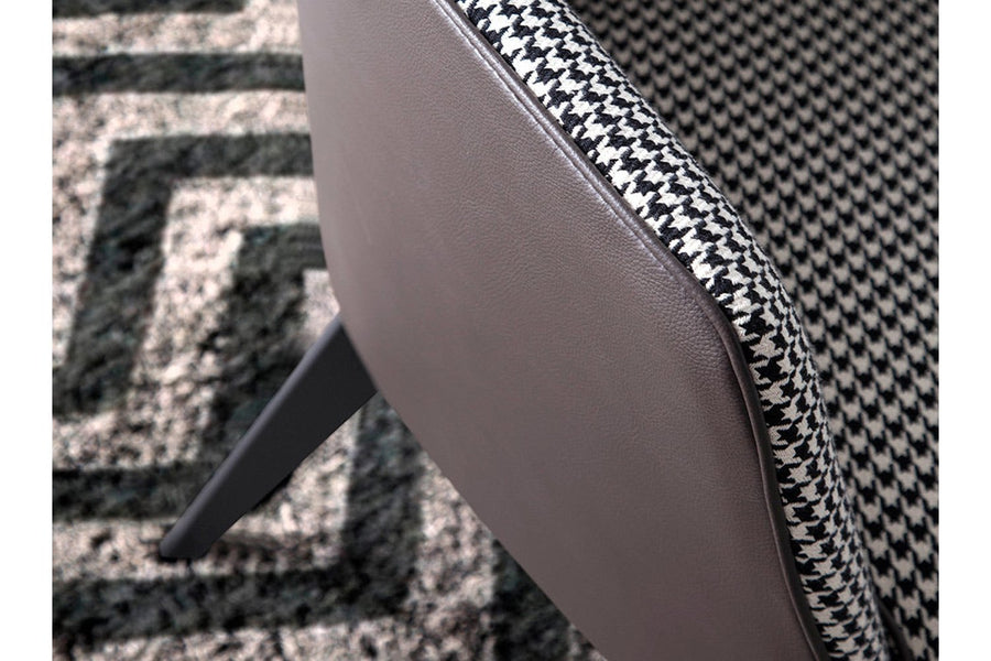 Kortárs stílusú, fekete színű műbőrrel és pepita színű szövettel kárpitozott dizájn fotel.