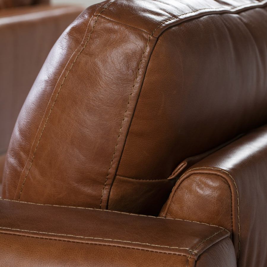 Kortárs stílusú, dohánybarna bőrrel kárpitozott, dizájn fotel diófa lábakkal.