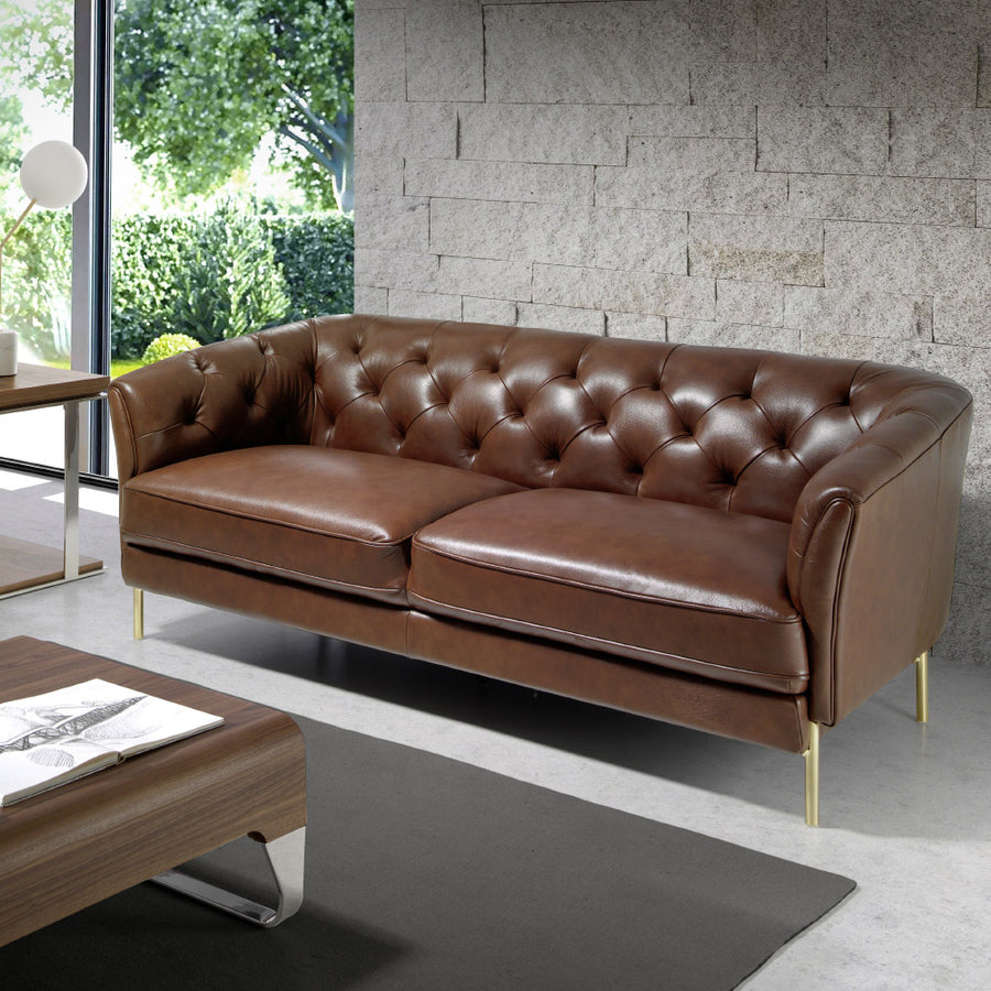 Kortárs stílusú, konyakszínű bőrrel kárpitozott, dizájn kanapé aranyszínű lábakkal.