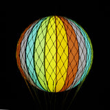 A szivárványszínű LED-es hőlégballon sötétben.