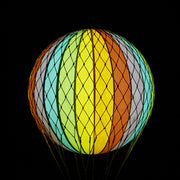 A szivárványszínű LED-es hőlégballon sötétben.