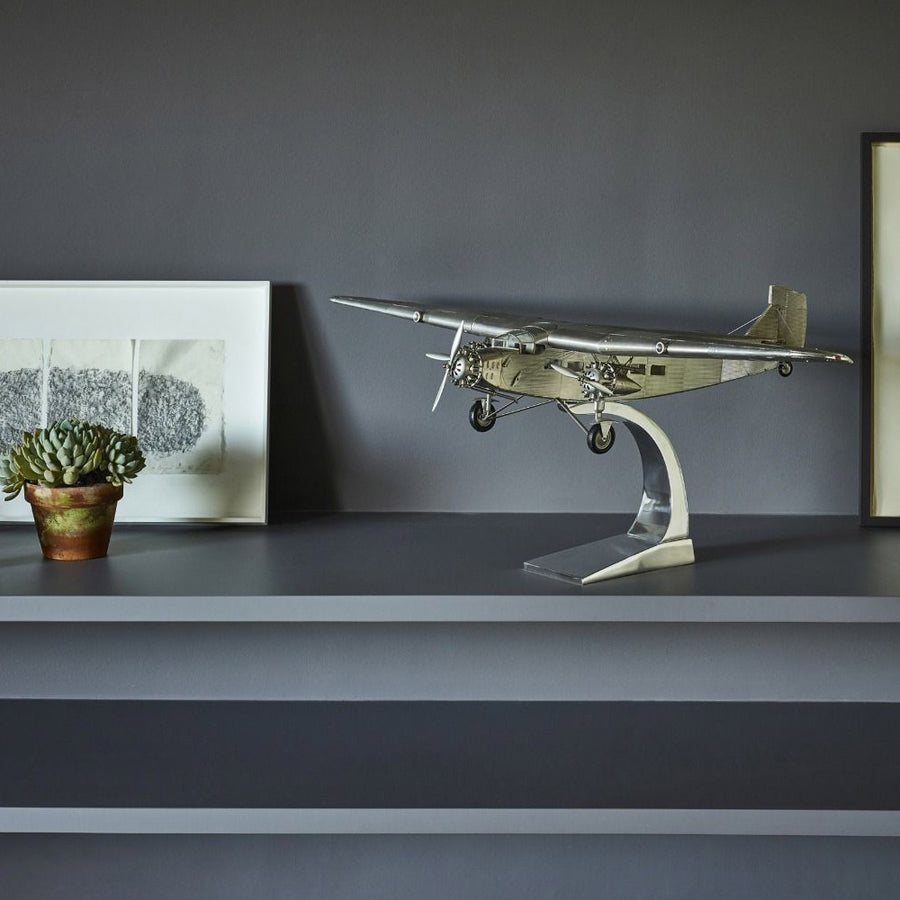 Fémből készült, részletgazdag, ezüstszínű Ford Trimotor repülőgép-modell állványon
