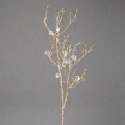 Teljes méretű aranyszínű gyémántos dekorációs ág szürke háttér előtt.