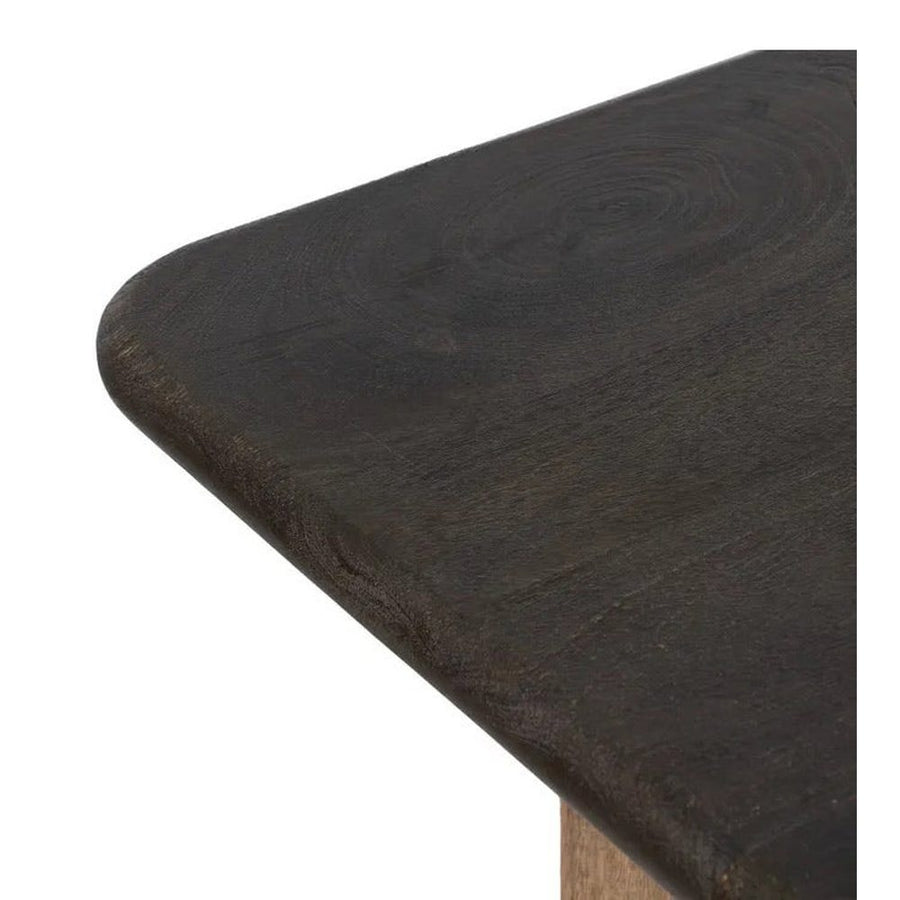 A kortárs stílusú, mangófából készült, natúr és sötétbarna színű étkezőasztal fedlapja.