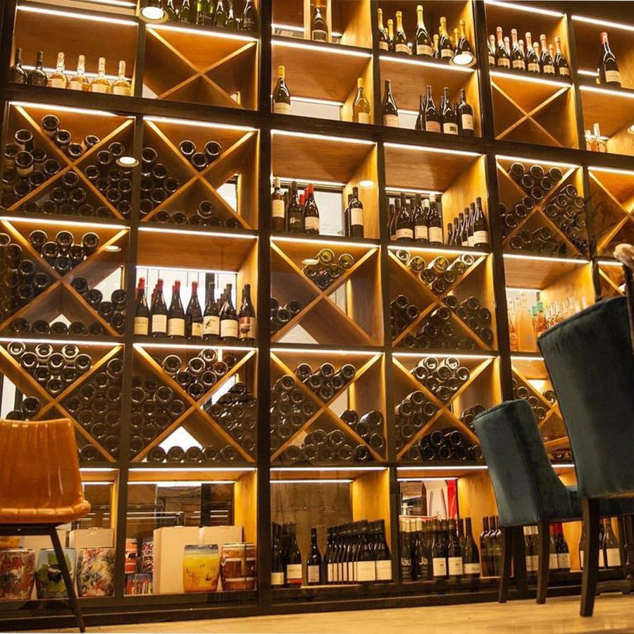 Egyedi tervezésű natúr és fekete színű palacktároló fal.