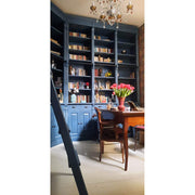 Egyedi tervezésű, antikolt kék színű könyvszekrény-fal, ívelt falu dolgozó szobában.