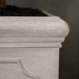 Heritage matt taupe fiberstone kaspó profilozott felső peremének és finoman strukturált, természetes kőhatású felületének közeli részlete.