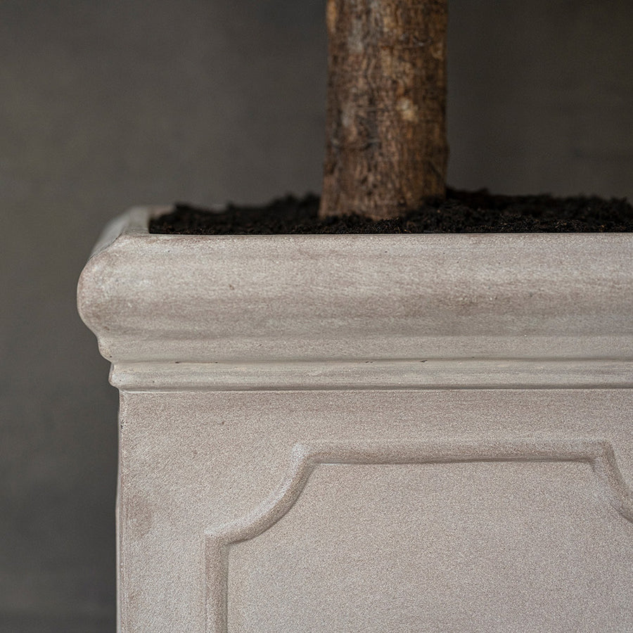 Heritage matt taupe fiberstone kaspó profilozott felső peremének, klasszikus keretezett díszítésének és kőhatású felületének részlete.