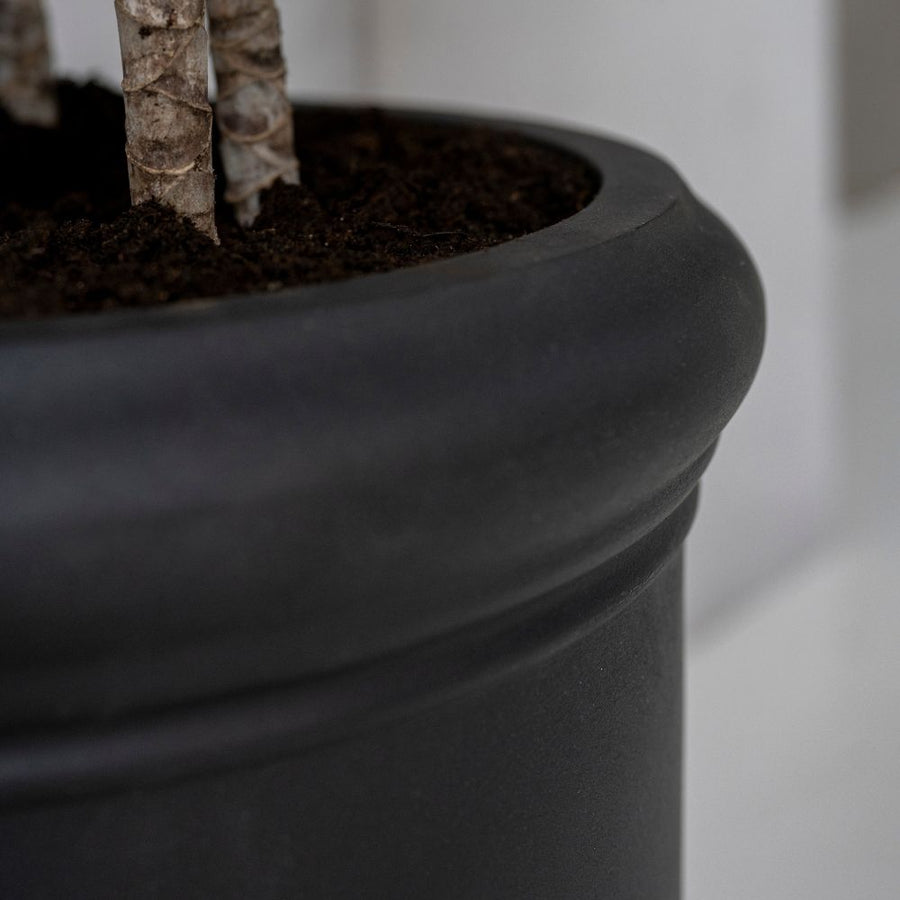 Heritage matt fekete fiberstone kaspó lekerekített, profilozott felső peremének és finoman strukturált felületének közeli részlete.