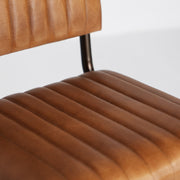 Loft stílusú, hajlított fémcső szerkezetű, barna színű bőrrel kárpitozott szék.