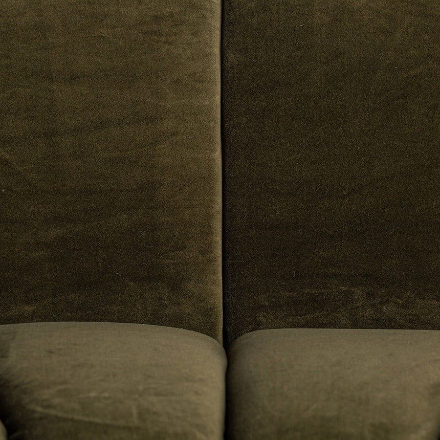 A kortárs stílusú, olajzöl bársonnyal kárpizotott moduláris kanapé háttámla részlete.