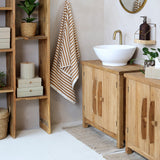 AIKA natúr szilfa kisszekrény fürdőszobai környezetben, léces fa fronttal és természetes felülettel
