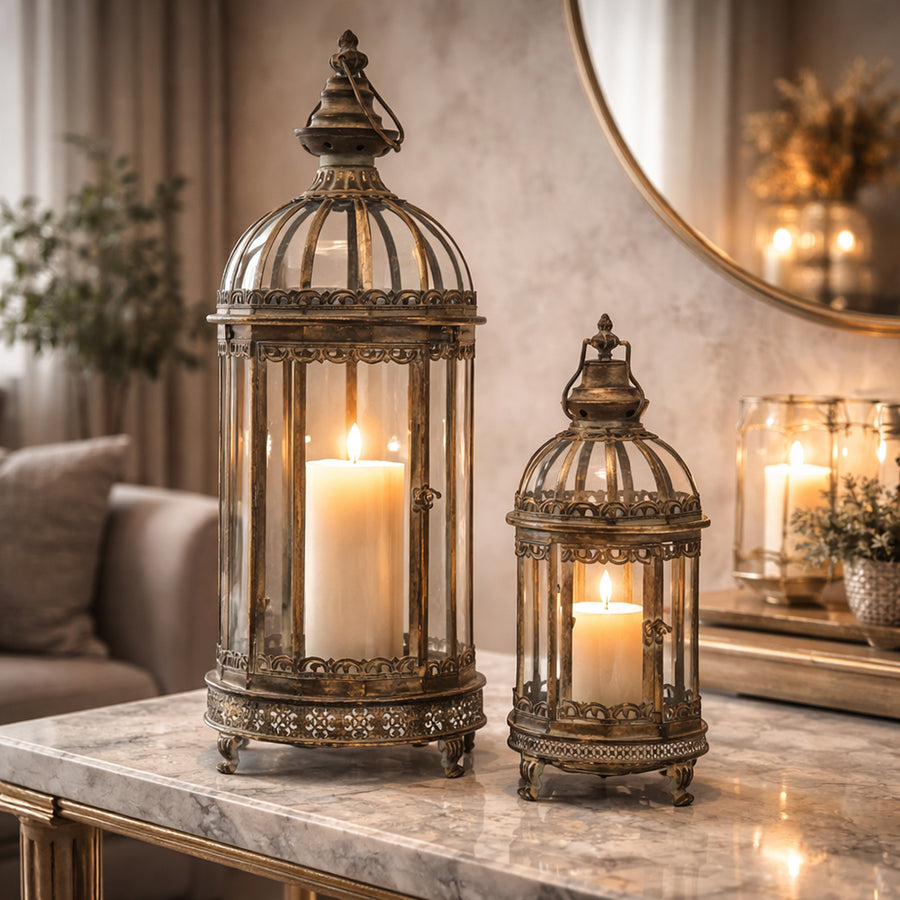 Antique Metals aranyszínű fém lámpás szett égő gyertyával elegáns nappali enteriőrben, márvány asztalon