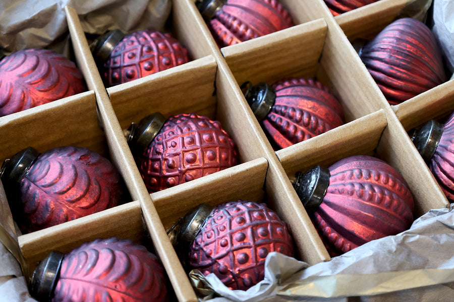 Antik meggybordó üveggömb díszek részletes mintázattal, díszdobozban elrendezve